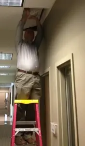 Jason Wood halfway into a ceiling during a physical penetration test