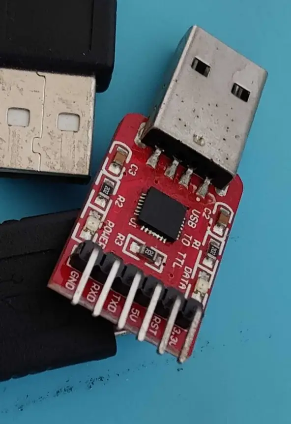 Close-up photograph of pin header labels on the USB to UART board showing DTR, RXD, TXD, VCC, CTS, and GND